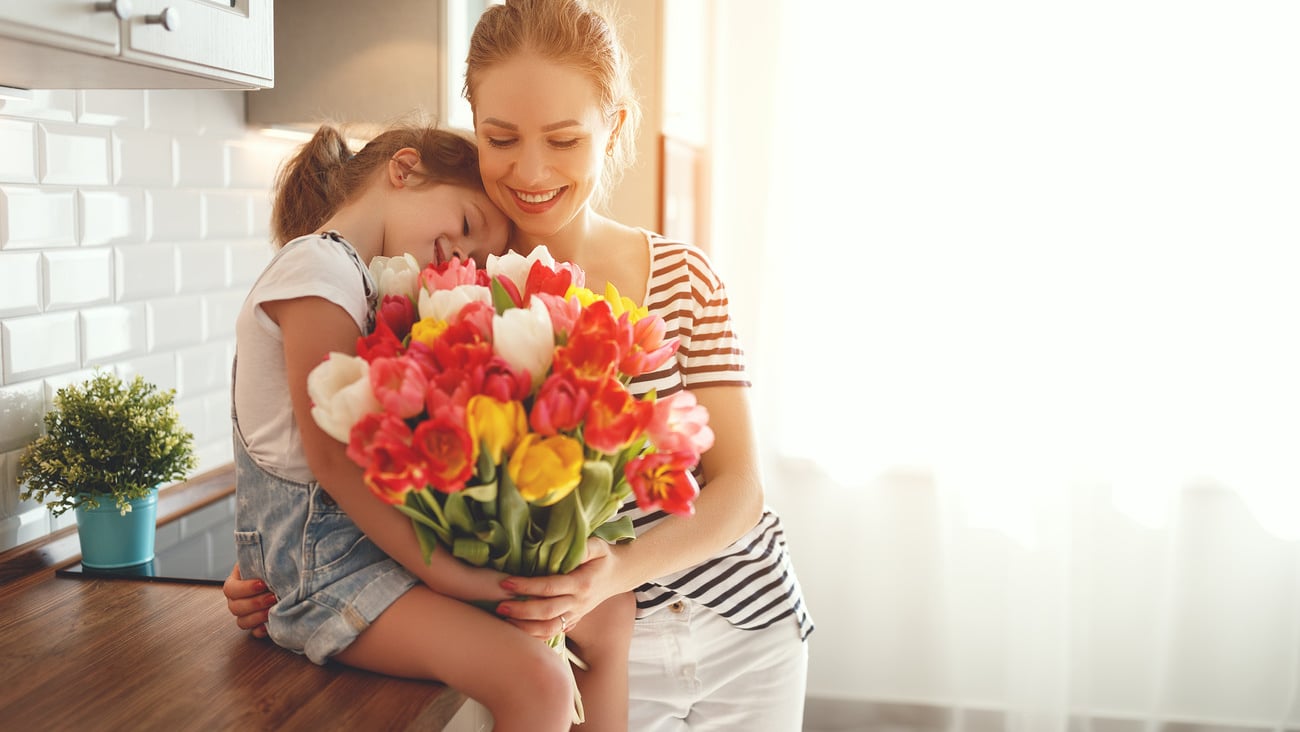 happy mother's day! child daughter congratulates mother and gives a bouquet of flowers to tulips.; Shutterstock ID 1038404041