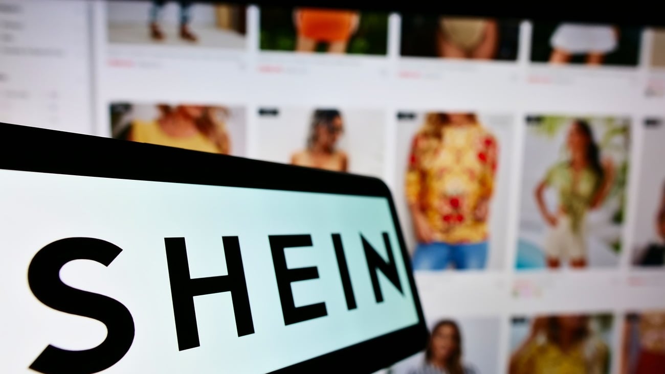 STUTTGART, GERMANY - Aug 14, 2021: Mobile phone with logo of Chinese e-commerce company Shein on screen in front of business website  Focus on center-left of phone display ; Shutterstock ID 2037893222