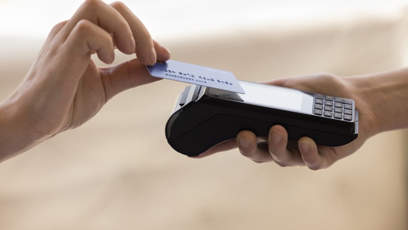 Close up with copy space unknown customer hold credit or debit card make easy payment on card reader machine with wireless NFC technology, client pay for order on terminal contactless, cashless method; Shutterstock ID 2295928753