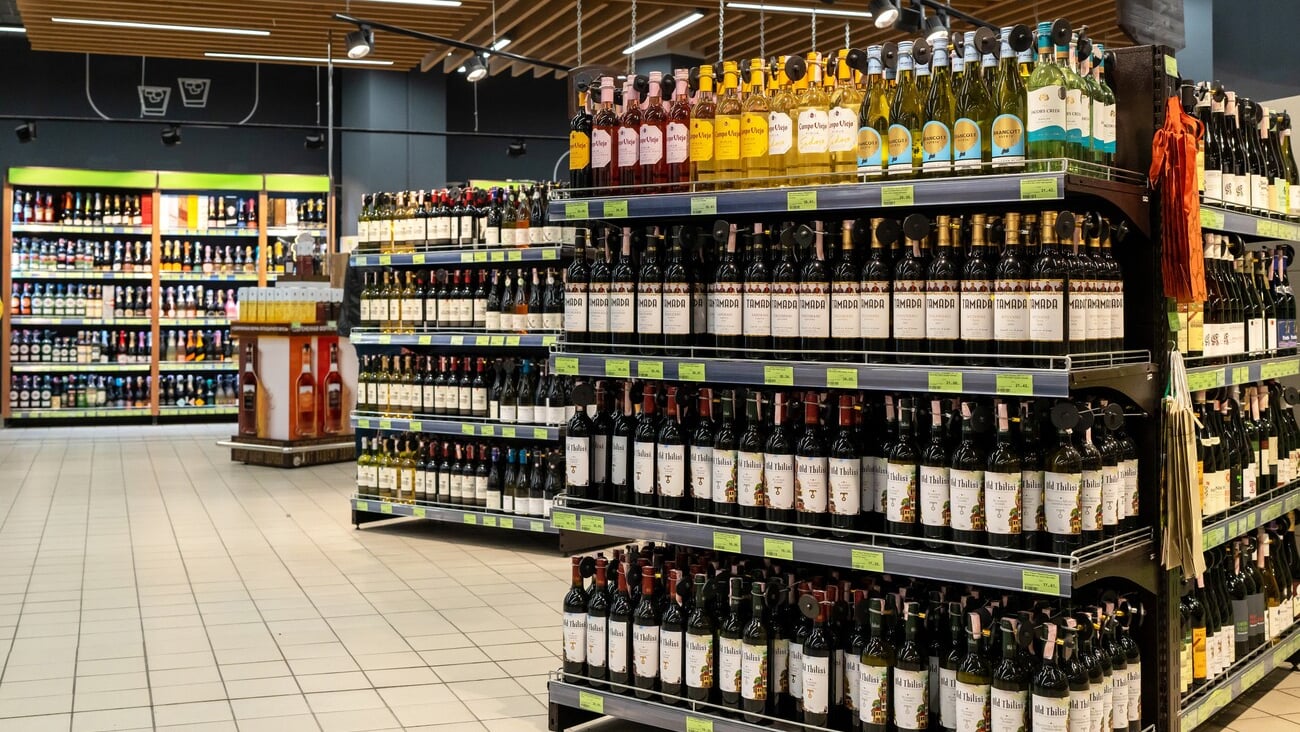 An assortment of imported wine and hard liquor bottles display neatly on store shelves. Alcohol retail business. Minsk, Belarus - July 8, 2024; Shutterstock ID 2486159995