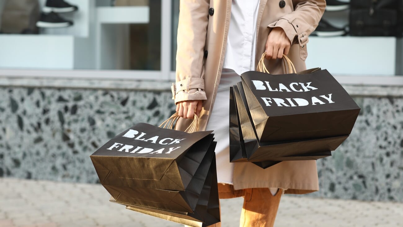 Beautiful young woman with shopping bags on city street, closeup. Black Friday sale; Shutterstock ID 2527885251