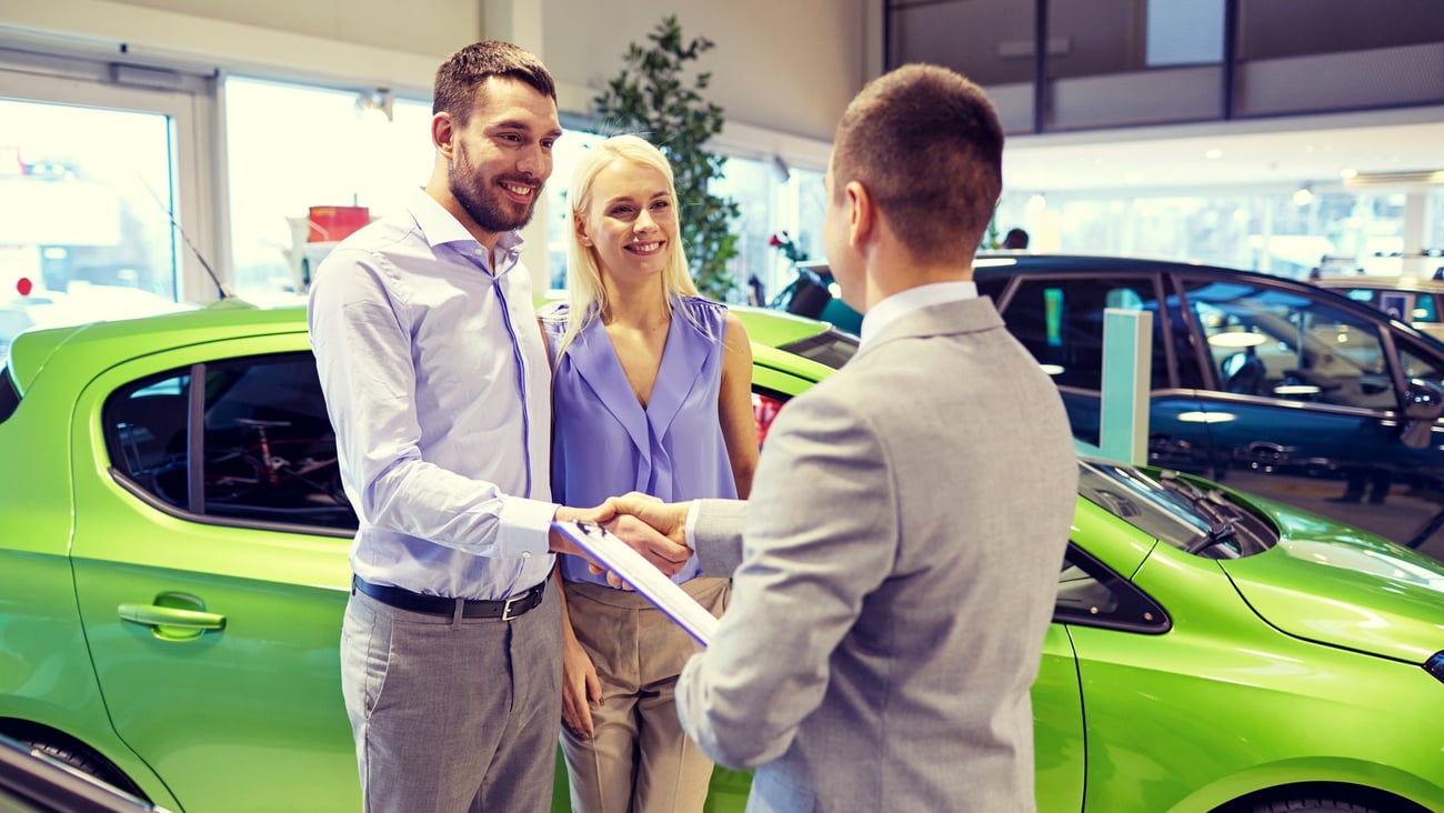 auto business, car sale and people concept - happy couple with dealer shaking hands in auto show or salon; Shutterstock ID 398901460