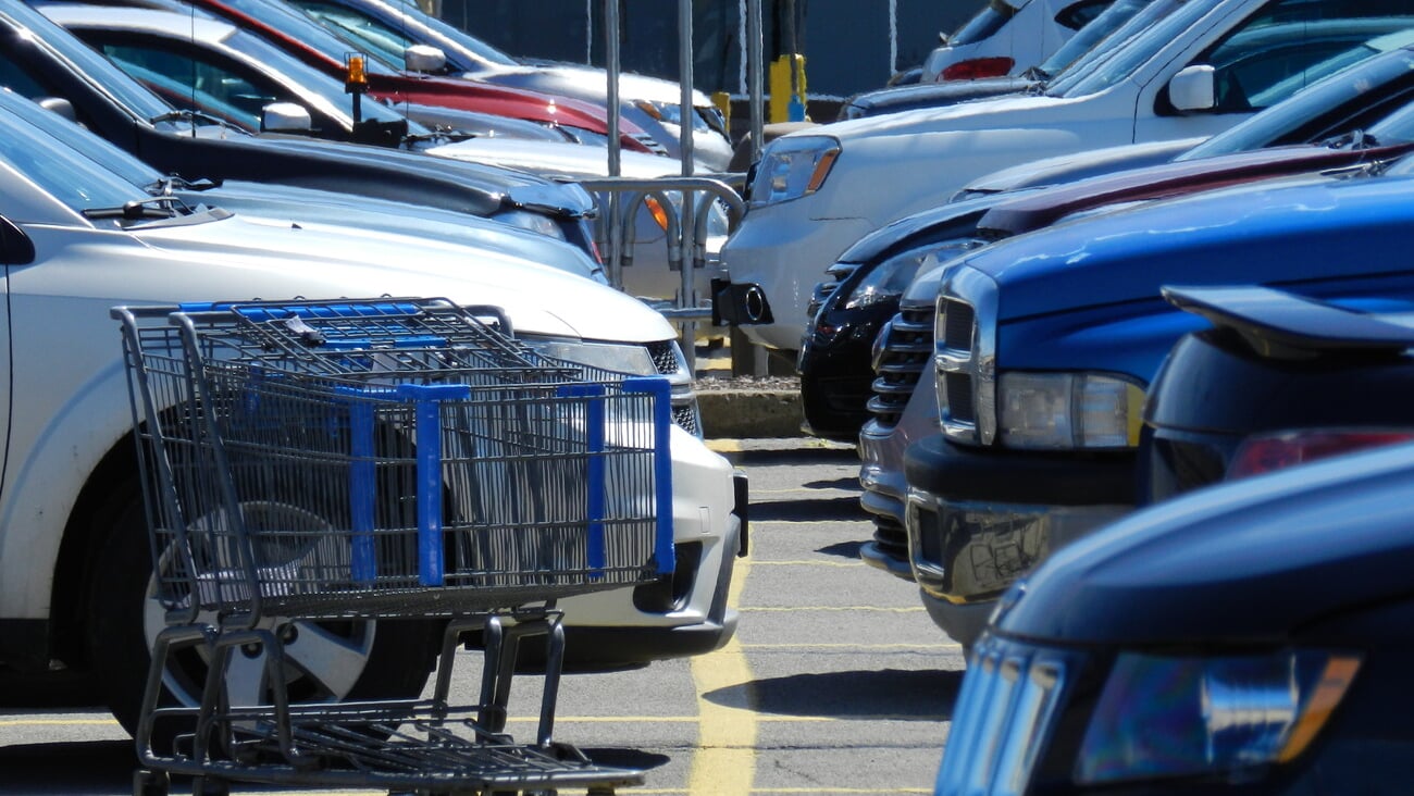 Shopping cart on a parking lot with cars; Shutterstock ID 622783607