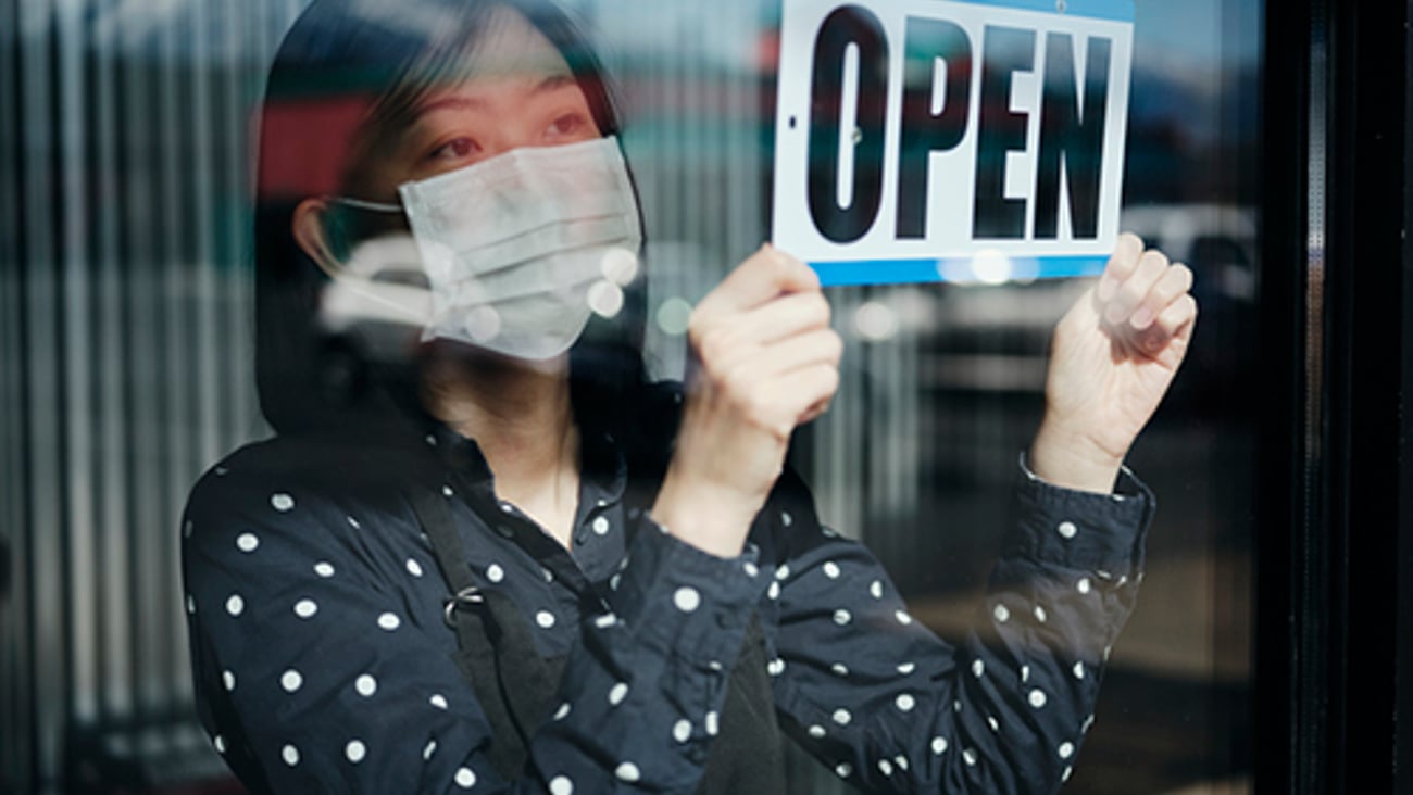 woman holding store open sign