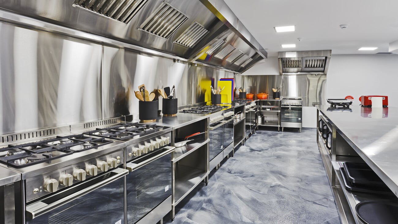 Modern shiny kitchen with stainless still kitchenware and equipment for restaurant-scale cooking with preparation tables, pans, pots, stoves.; Shutterstock ID 605311271