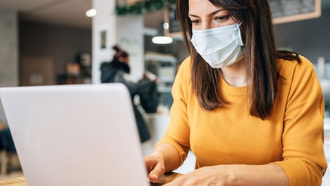 woman on laptop wearing mask