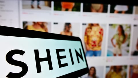 STUTTGART, GERMANY - Aug 14, 2021: Mobile phone with logo of Chinese e-commerce company Shein on screen in front of business website  Focus on center-left of phone display ; Shutterstock ID 2037893222
