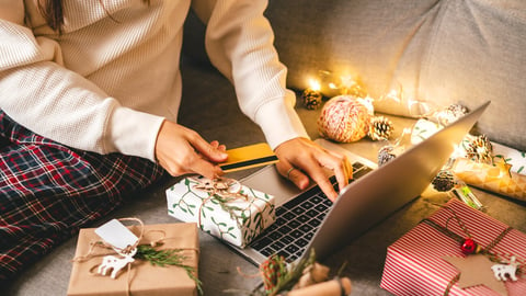 Close up of woman hands with credit card, gifts, and laptop. Online shopping at Christmas holidays. Cropped female sit on couch with natural eco presents and decor. Merry Christmas packing Concept.; Shutterstock ID 2067652718