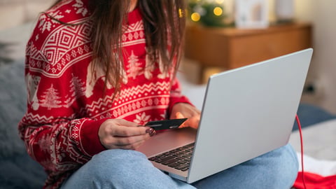 Christmas online shopping, sales and discounts promotions during winter holidays, online shopping at home. Female hands on the laptop with credit card and blurred bokeh lights; Shutterstock ID 2383010591