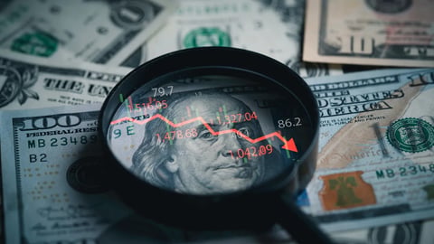 Red down arrow inside of magnifier glass and USD dollar banknote for United States of America or USA economic recession concept.; Shutterstock ID 2501604651
