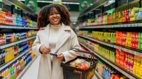 With a basket in hand a beautiful curly hair black woman searching and buying groceries in super market.; Shutterstock ID 2408060911