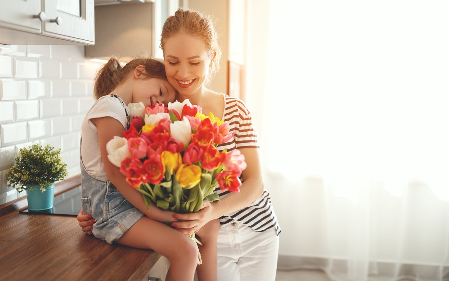 happy mother's day! child daughter congratulates mother and gives a bouquet of flowers to tulips.; Shutterstock ID 1038404041