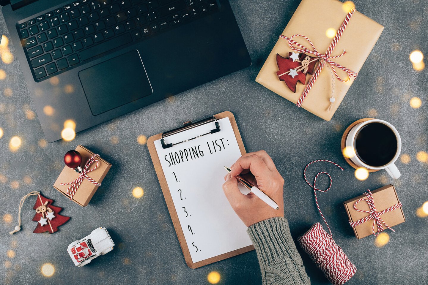 Christmas online shopping flat lay. Girl writing shopping list. Laptop, present box, cup of coffee, holiday decoration. Winter holidays sales; Shutterstock ID 1816989257