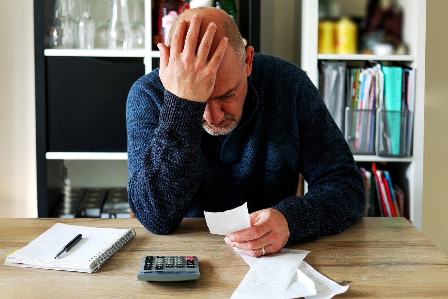 Man upset headache depressed from family cost got higher doing accounting holding receipts from supermarket with calculator by rising grocery prices and surging cost as an inflation financial crisis.; Shutterstock ID 2131821733