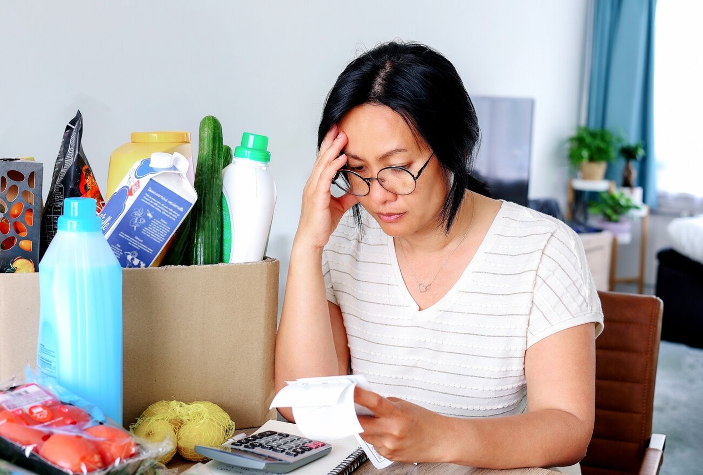 Living cost inflation crisis high cost in gas electric energy woman holding receipts from supermarket with calculator by rising grocery prices and surging cost as an inflation financial crisis.; Shutterstock ID 2162437299