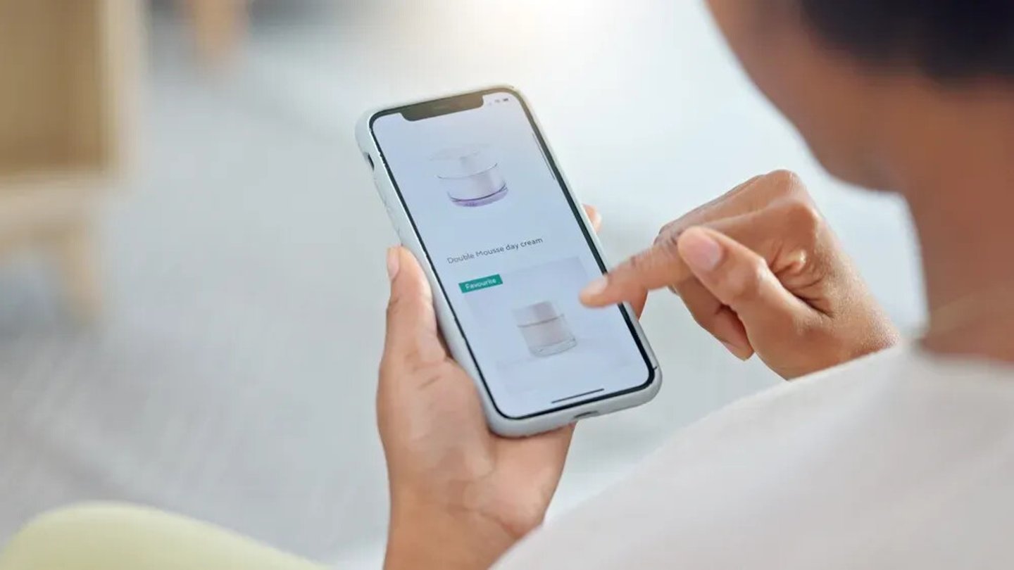 Shopping online and scrolling through makeup products to find a sale or discount. Hands of a woman browsing cosmetics on her phone from above. Enjoying the convenience and ease of purchasing apps; Shutterstock ID 2259436115
