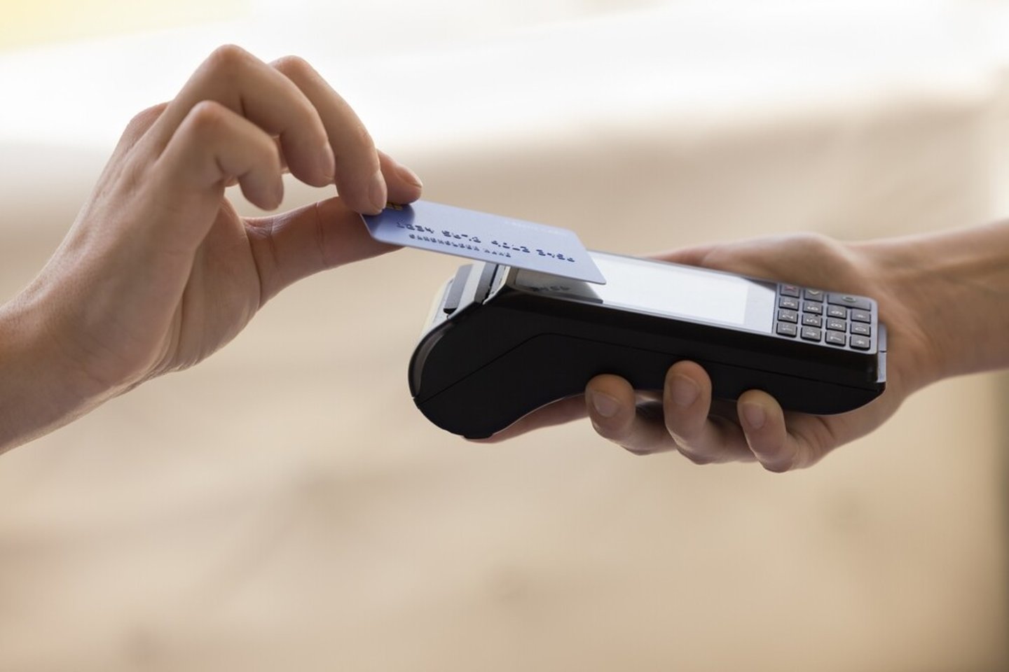 Close up with copy space unknown customer hold credit or debit card make easy payment on card reader machine with wireless NFC technology, client pay for order on terminal contactless, cashless method; Shutterstock ID 2295928753