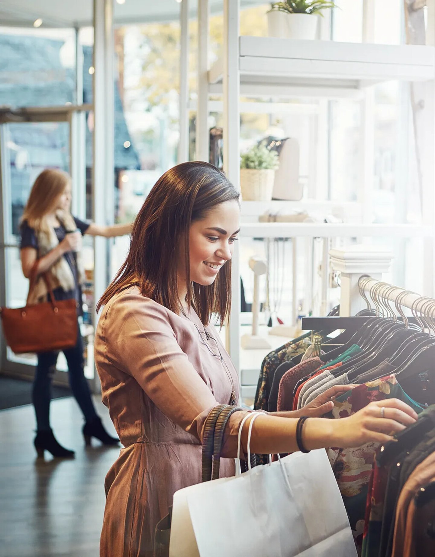 Retail, customer and woman with fashion, luxury and shopping with boutique items, selection and happiness. Female shopper, client and lady with clothes, sales discount and outfit choice in a store; Shutterstock ID 2315198339