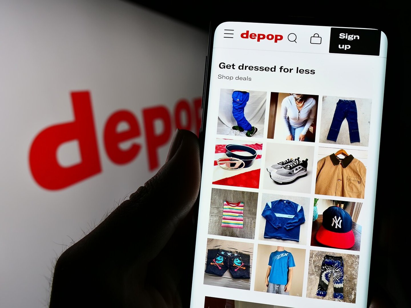 Stuttgart, Germany - 07-09-2023: Person holding cellphone with website of social e-commerce company Depop Limited on screen in front of logo. Focus on center of phone display. Unmodified photo.; Shutterstock ID 2335140141