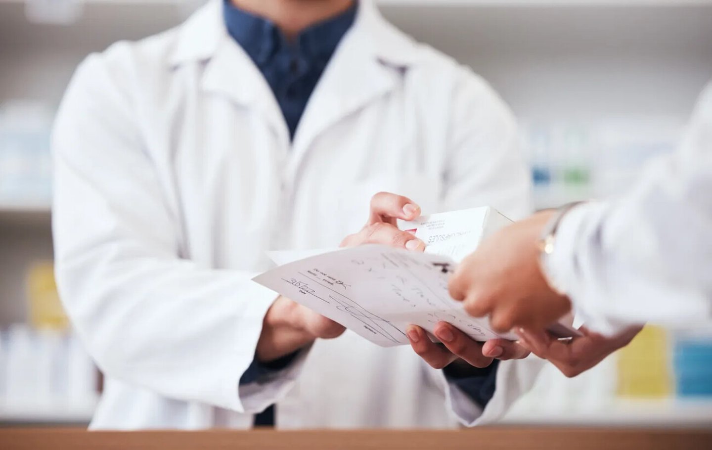 Healthcare, pharmacy and prescription medicine in hand of customer with paper, box or rx medication. Closeup of pharmacist or medical staff with person for pharmaceutical product at retail drugstore; Shutterstock ID 2353169745
