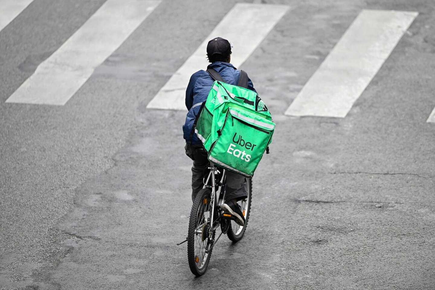 A deliver for Uber Eats or UberEats on his bike or bicycle. Illustration of delivers for home food meal takeaway delivery platforms, in Paris, France on October 19, 2023.; Shutterstock ID 2382852033