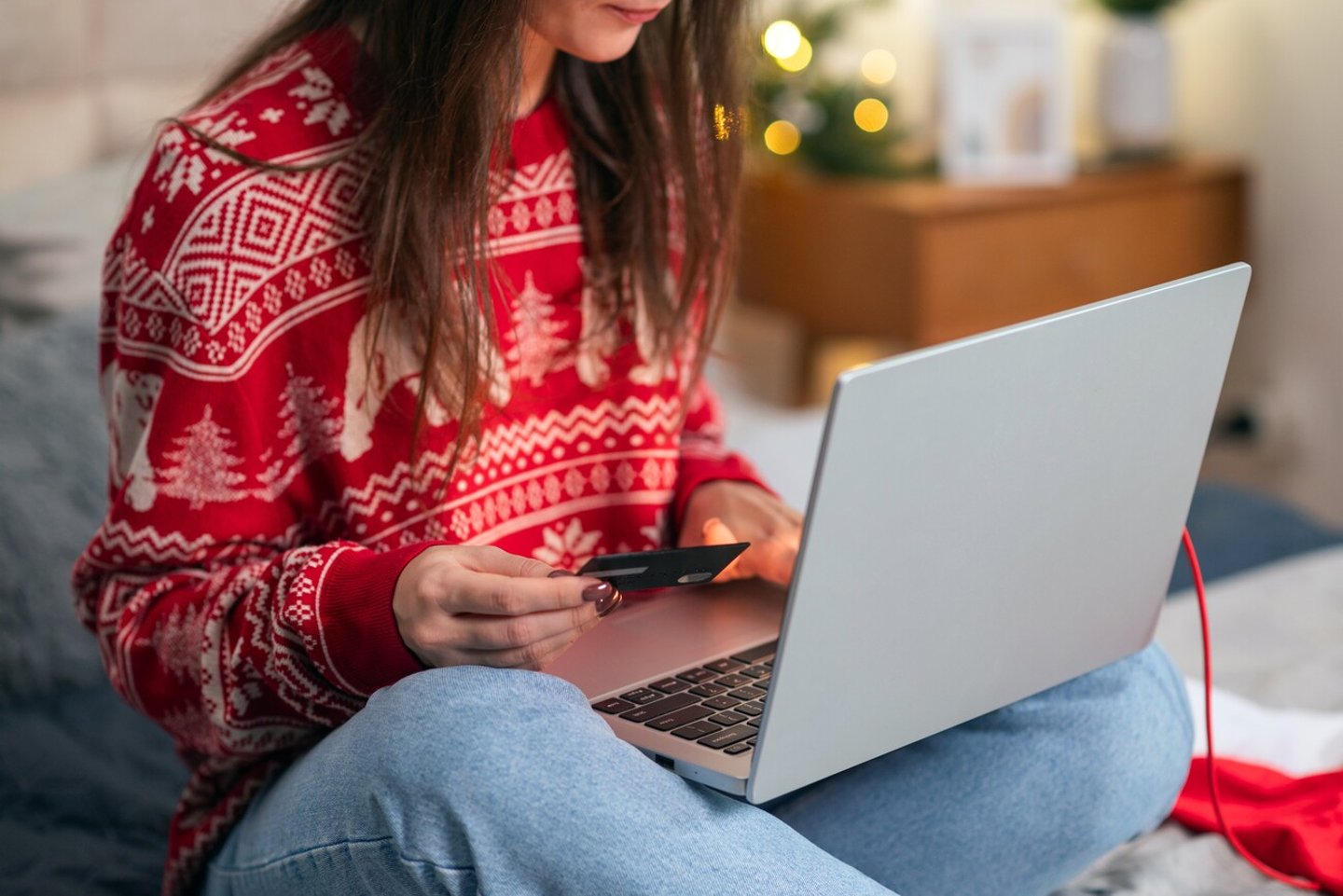 Christmas online shopping, sales and discounts promotions during winter holidays, online shopping at home. Female hands on the laptop with credit card and blurred bokeh lights; Shutterstock ID 2383010591