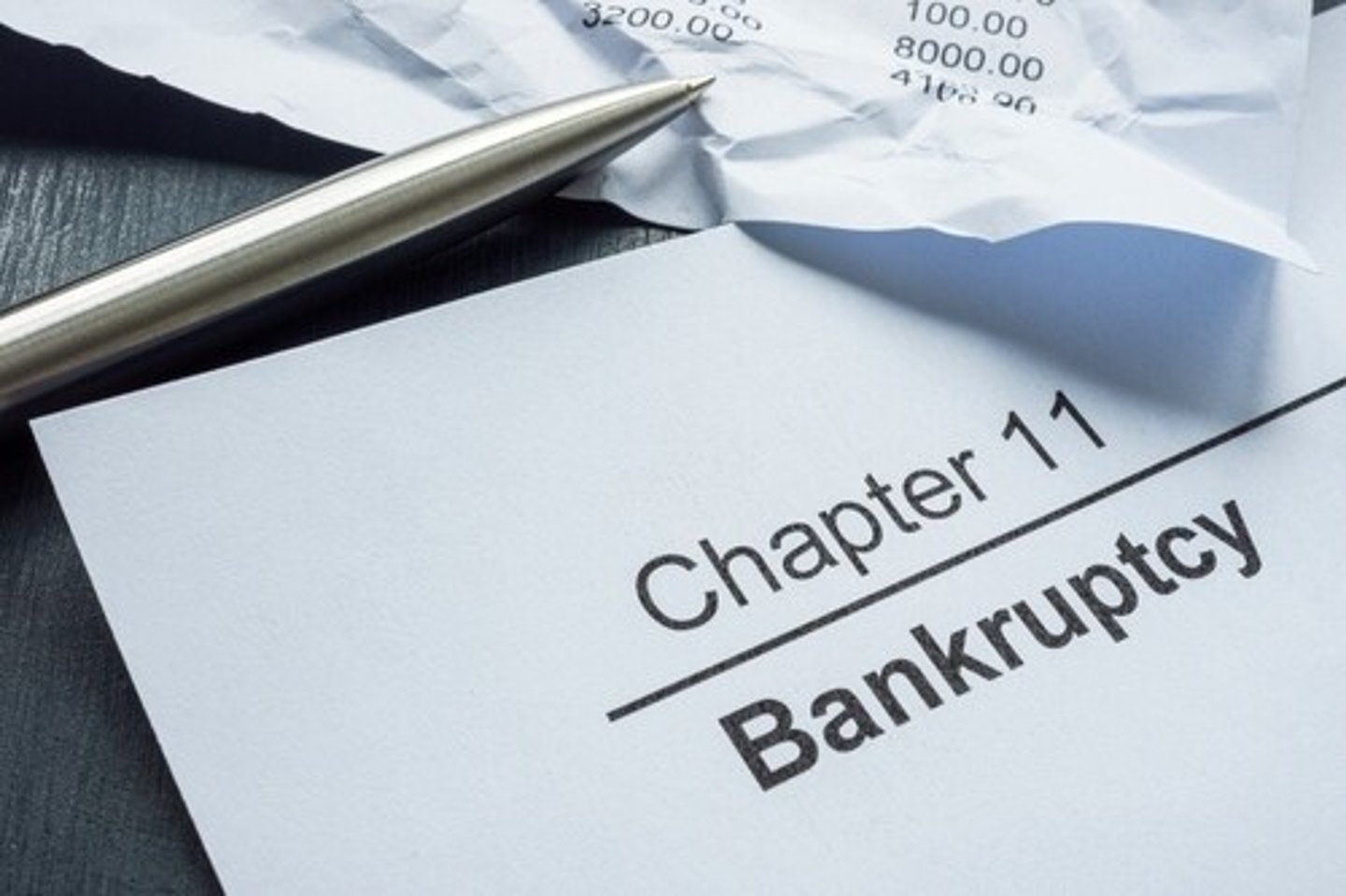 Chapter 11 bankruptcy and crumpled financial statement.; Shutterstock ID 2439174953