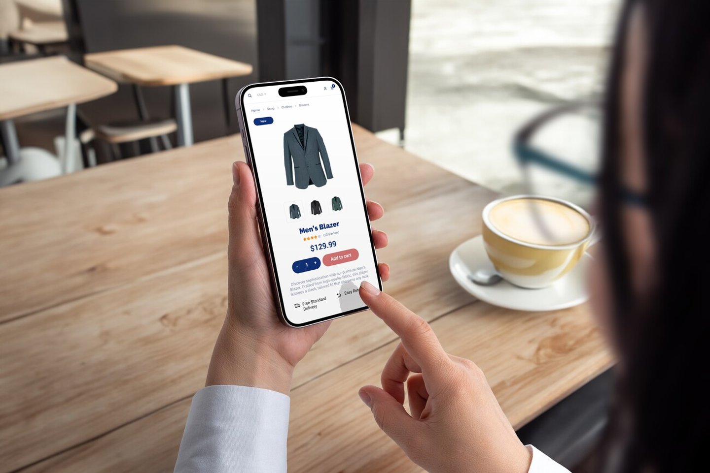Woman shops for men's blazer on smartphone. Modern ecommerce app interface concept for effortless browsing and purchasing of stylish clothing; Shutterstock ID 2456075197