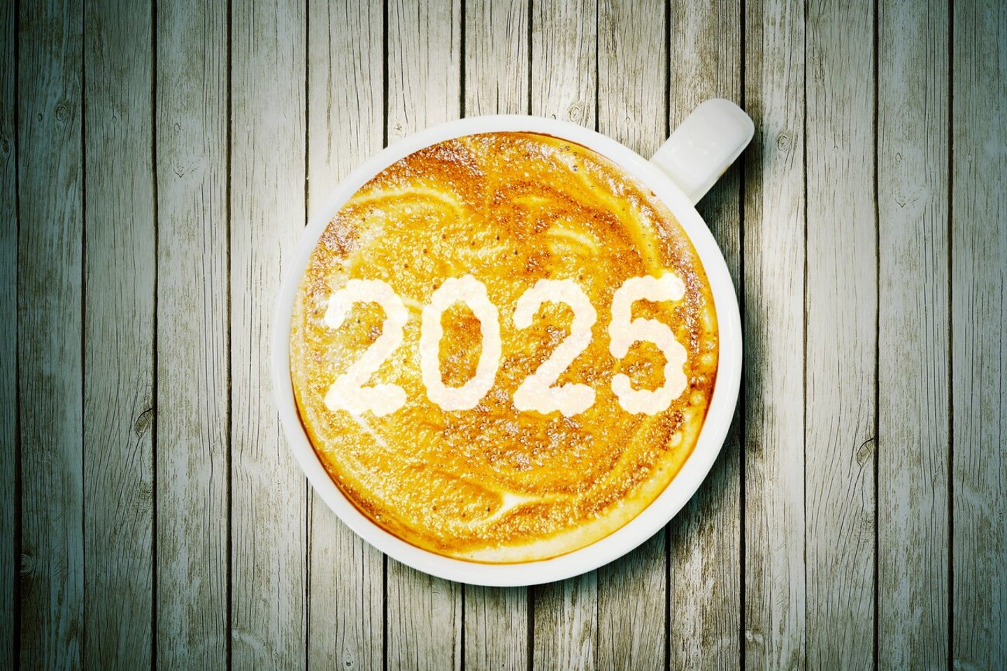 New year concept: Close up of number 2025 on frothy surface of cappuccino served in a cup above wooden table; Shutterstock ID 2498916977