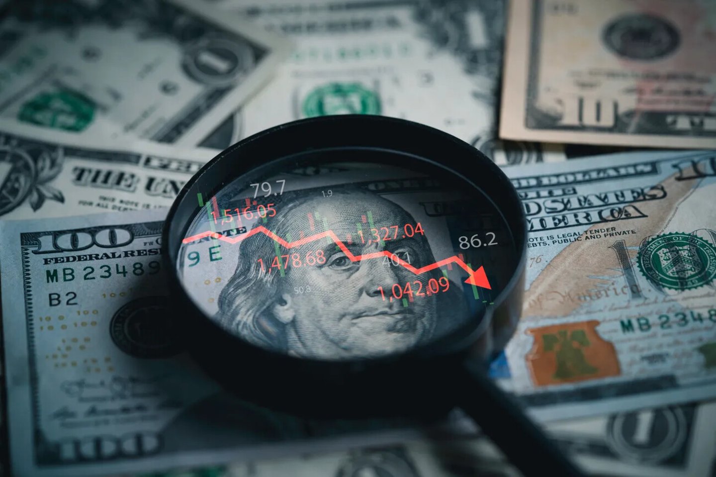 Red down arrow inside of magnifier glass and USD dollar banknote for United States of America or USA economic recession concept.; Shutterstock ID 2501604651