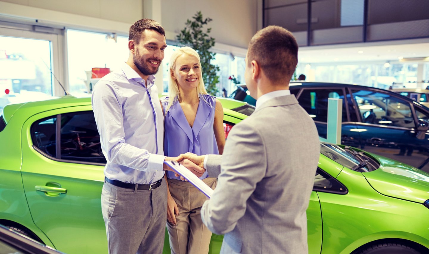auto business, car sale and people concept - happy couple with dealer shaking hands in auto show or salon; Shutterstock ID 398901460