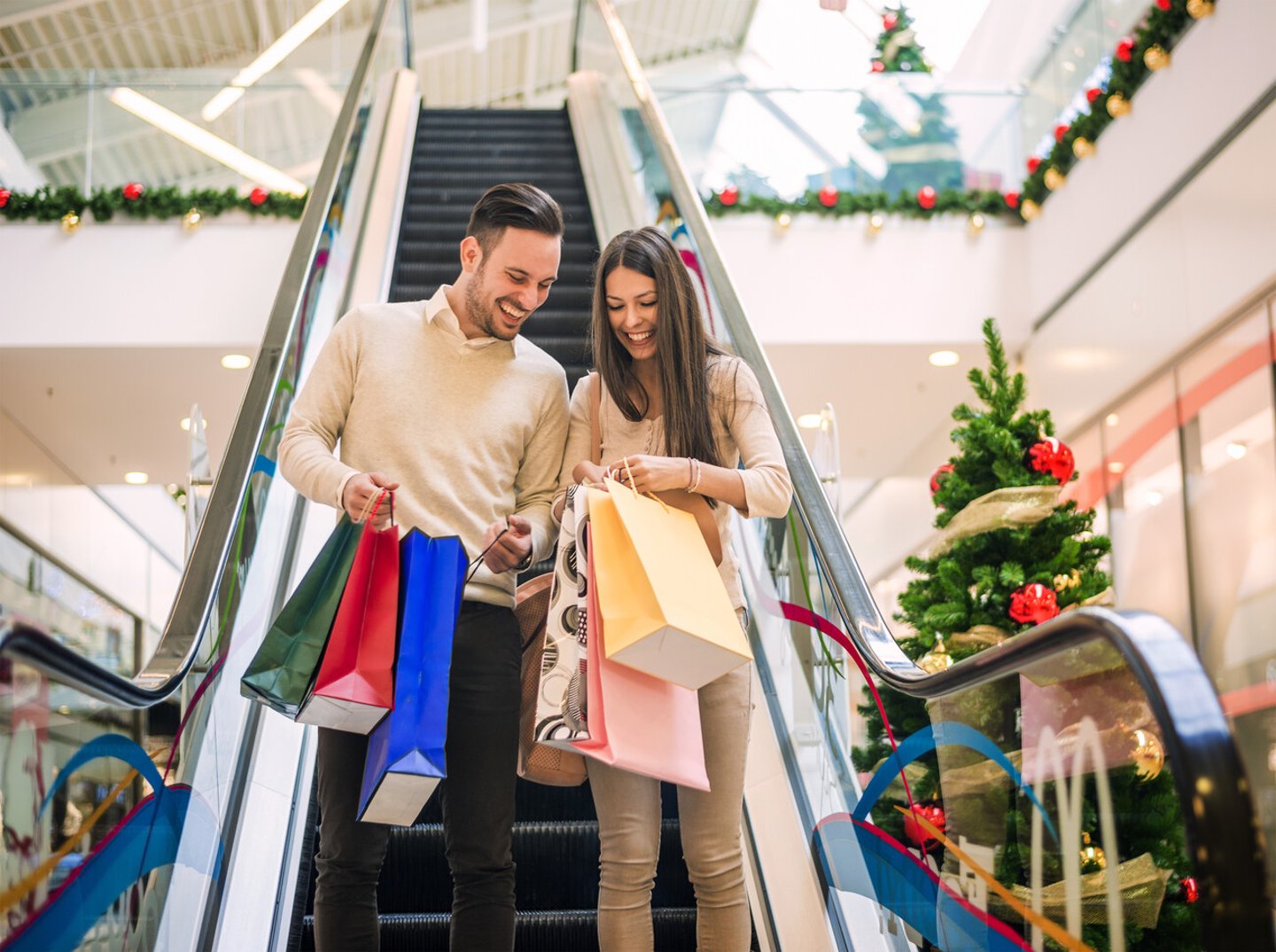 Romantic Christmas shopping.Sale, technology and people concept - happy young couple with shopping bags.Image taken inside a shopping mall.Selective focus; Shutterstock ID 356223023