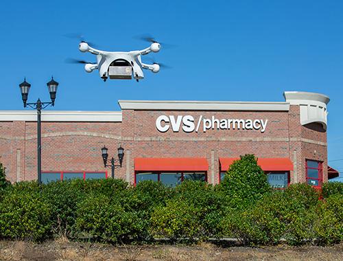 Drone holding UPS package flying over CVS