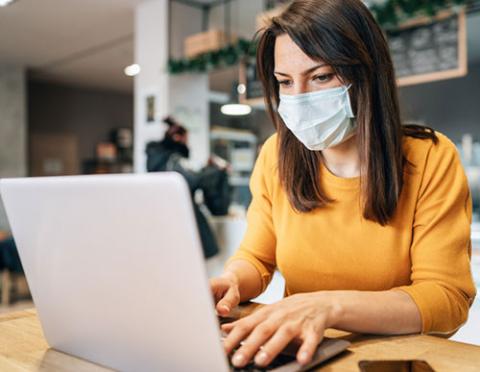 woman on laptop wearing mask