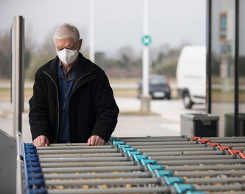 man with grocery cart wearing mask
