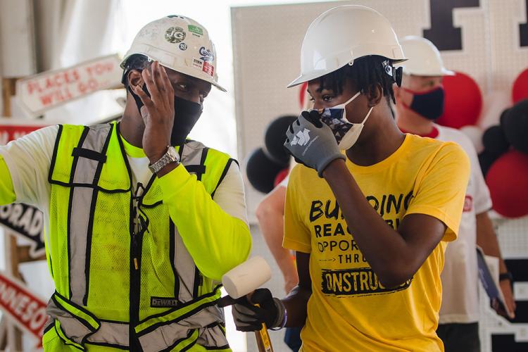 A ConstructReach participant receives guidance from the construction team at the Lake Street store during a volunteer event this summer.